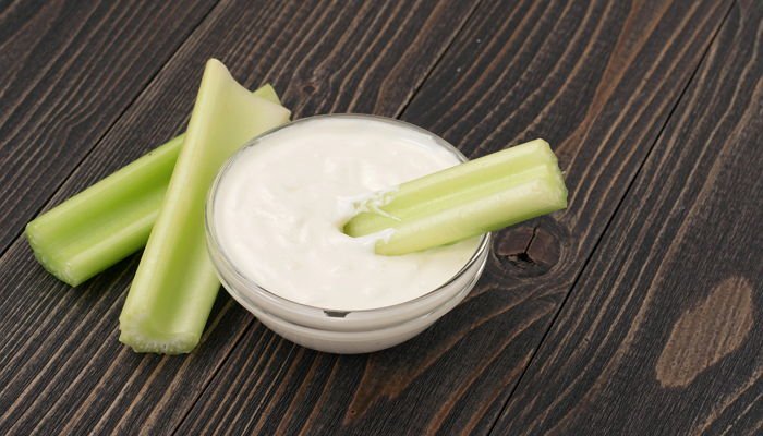 Celery sticks with sour cream closeup with copy space. Delicious and useful food