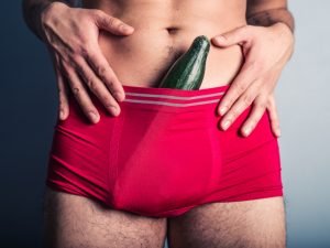 Young man with cucumber in his underpants