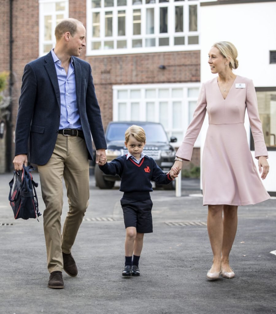 Britain's Prince George (C) accompanied by Britain's Prince William (L), Duke of Cambridge arrives for his first day of school at Thomas's school where he is met by Helen Haslem (R) head of the lower school on September 7, 2017 in southwest London. / AFP PHOTO / POOL / RICHARD POHLE