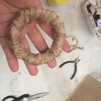 クラフト紙を固定しつつ麻紐を周囲にグルグル巻きつけていきます。 巻き終わりは輪になる部分を作っておけば、のちのち引っ掻ける部分にもなります☆