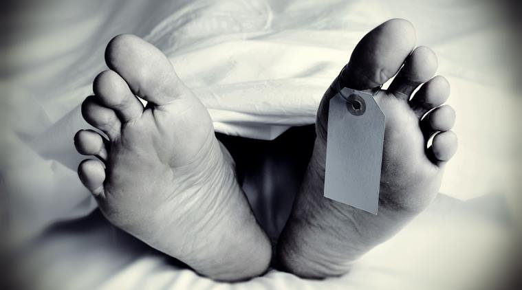 closeup of the feet of a dead body covered with a sheet, with a blank tag tied on the big toe of his left foot, in monochrome, with a vignette added