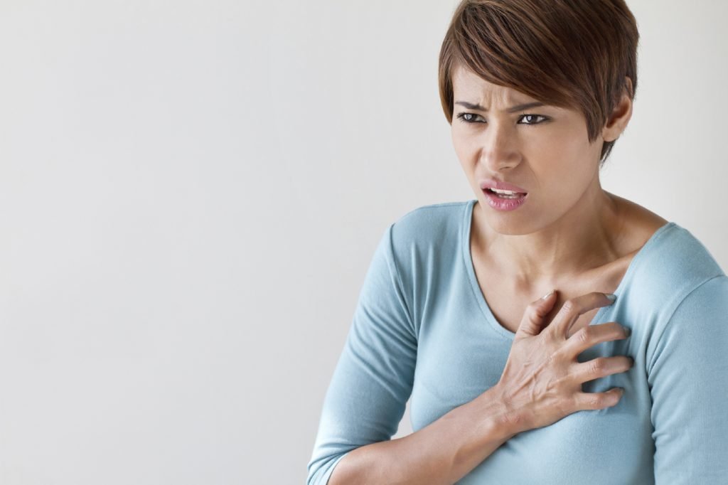 femme malade avec symptôme de crise cardiaque soudaine