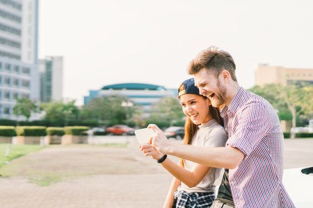 74109466 - happy multiethnic couple taking selfie during sunset in the city, fun and smiling, love or gadget technology concept