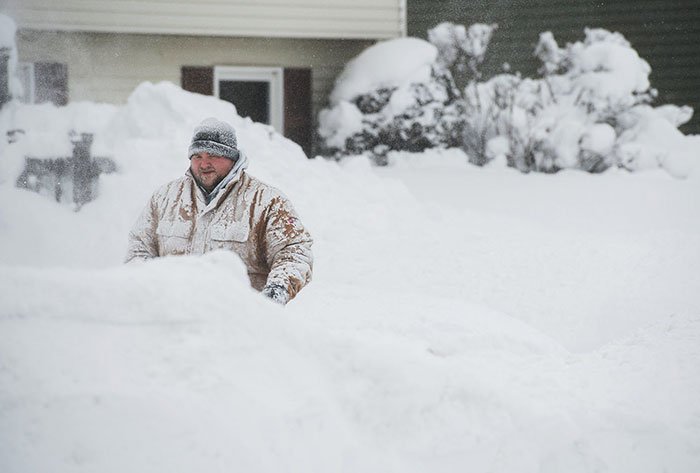 A Man Removes Snow From The Sidewalk In Front Of His Home After Two Days Of Record-Breaking Snowfall In Erie, Pennsylvania