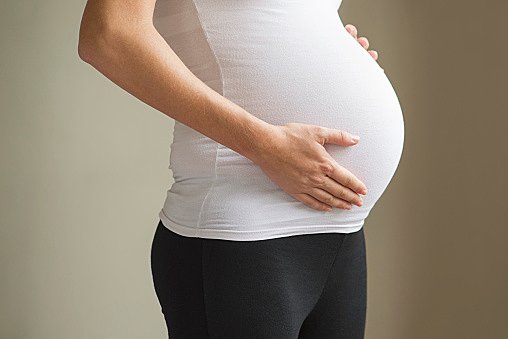 Pregnant woman touching abdomen