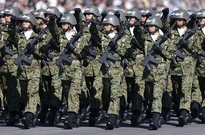 Members of Japan's Self-Defence Forces' airborne troops march during the annual SDF troop review ceremony at Asaka Base in Asaka, near Tokyo October 27, 2013. Japanese Prime Minister Shinzo Abe, in an interview published on Saturday, said Japan was ready to be more assertive towards China as Beijing threatened to strike back if provoked. REUTERS/Issei Kato (JAPAN - Tags: POLITICS MILITARY) - RTX14PU2