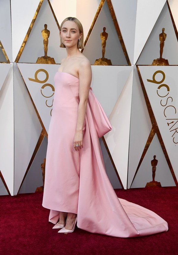 Saoirse Ronan apostó por rosa chicle. Su diseño exclusivamente hecho a medida por la firma Calvin Klein. Strapless y con un gran moño y stilettos en punta que completaban el soñado outfit