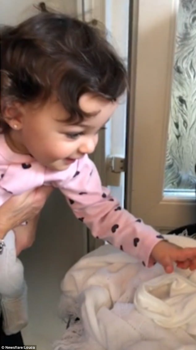 This is the heart-melting moment a little girl squeals with delight as she meets her newborn sister for the first time 