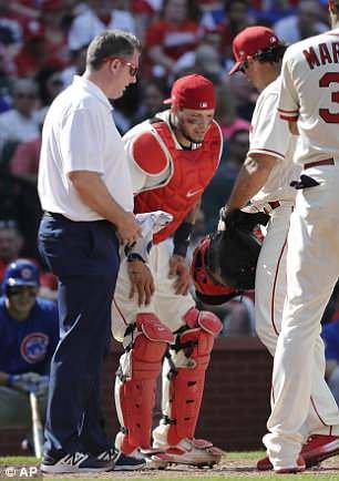 Catcher Yadier Molina grimaces in pain after a foul tip off a 102mph fastball struck him in the groin on Saturday in St. Louis