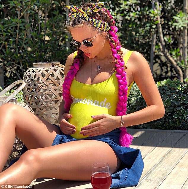 Xenia Deli, 28, está esperando seu primeiro filho com seu marido bilionário, postando esse estalo de sua barriga protuberante sob um top amarelo e segurando seu estômago para o Instagram