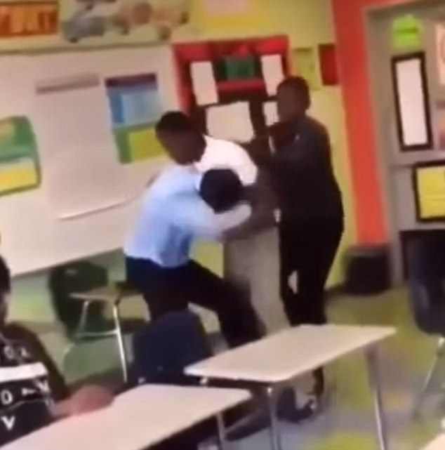 O aluno se levantou do chão para atacar o professor mais uma vez enquanto seu colega tentava puxá-lo de volta