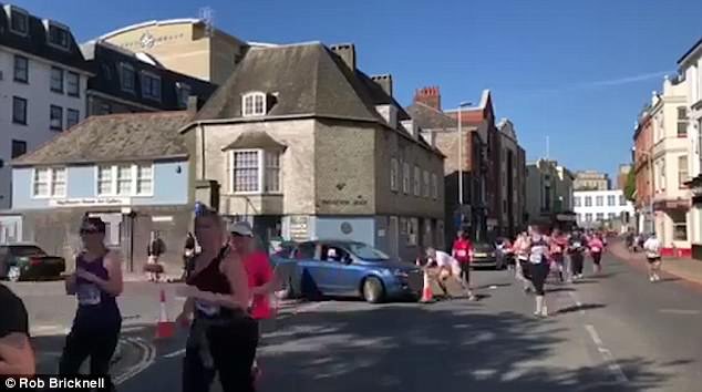 Driver was caught on camera in Plymouth knocking over a cone and almost injuring runners as they attempt to block the vehicle ploughing into participants in the city