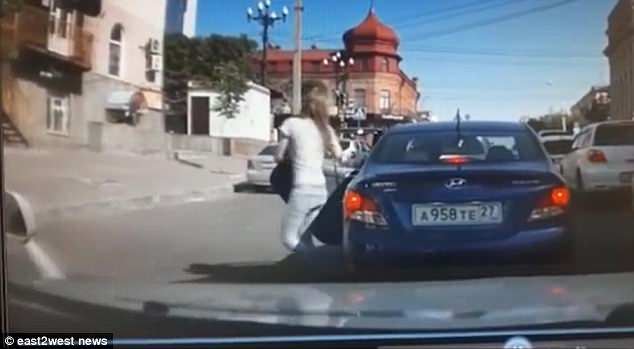 This is the horrific moment a spurned husband deliberately mowed down his wife after she told him wanted a divorce.Â The shocking incident was captured on camera in the city of Khabarovsk, eastern Russia