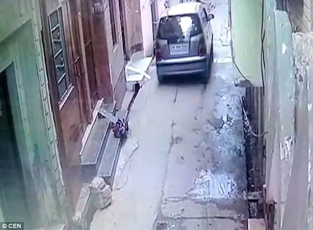 Security camera footage shows a silver Hyundai Santro stop in the residential area just after 8am. The baby girl was wrapped in a blanket and left precariously on the edge of the doorstep - right in the path of oncoming vehicles