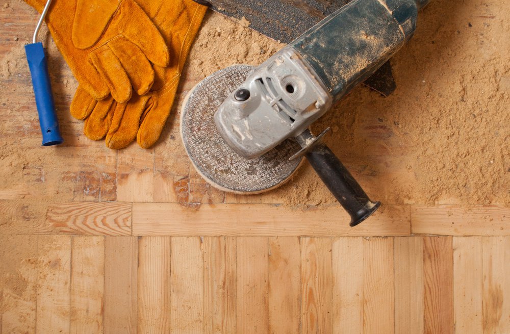 home renovation, parquet sanding, polishing. repair in the apartment. New home. working gloves. The polished wood working. Old working tools. Many working tools on a wooden background.