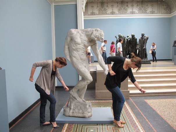 Funny People posing with statues 