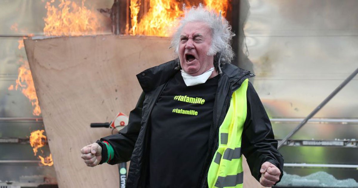 yellow vest protester attempts to throw back a tear gas canister during clashes with riot police.jpg?resize=1200,630 - Yellow Vest Protesters Smash And Set Fire On Stores In Paris