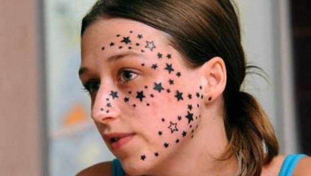 Star power: Kimberley Vlaminck displays her tattooed face. The 56 stars will cost Â£8,500 to remove - and even then will leave her face covered in scars