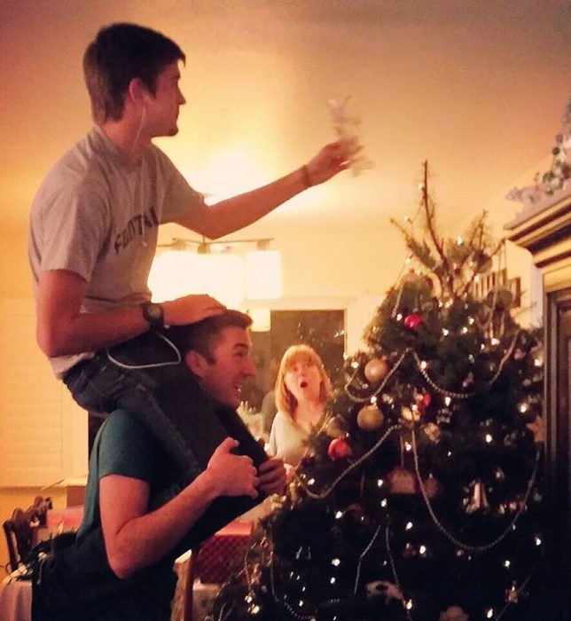 hermanos jóvenes poniendo el árbol de navidad