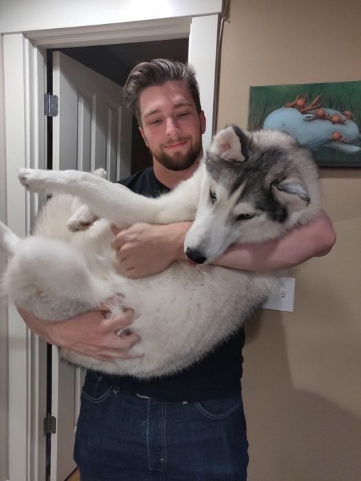 hombre cargando a un perro 