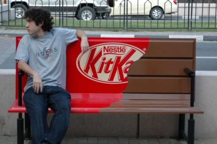 joven sentado en banca pintada como un chocolate