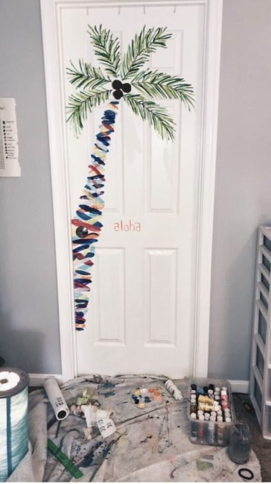 Puerta de una habitación decorada con una palmera dibujada a mano 