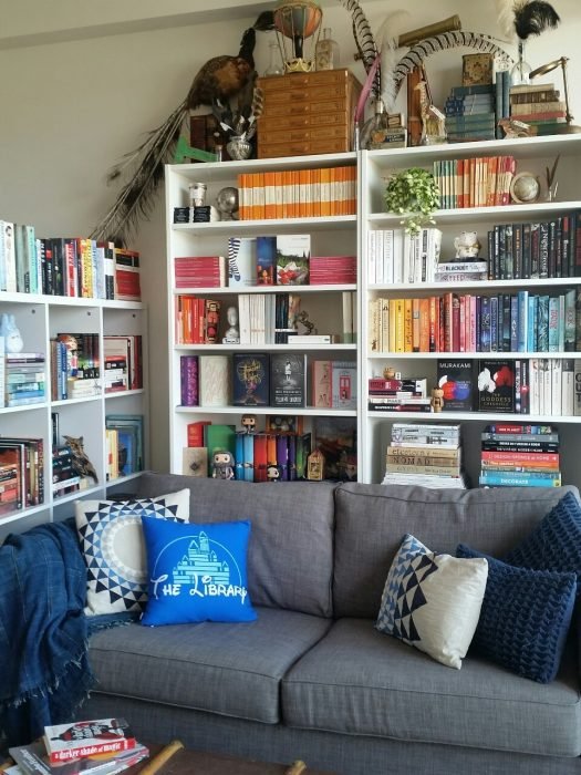 estanterías de libros detrás de un sillón gris