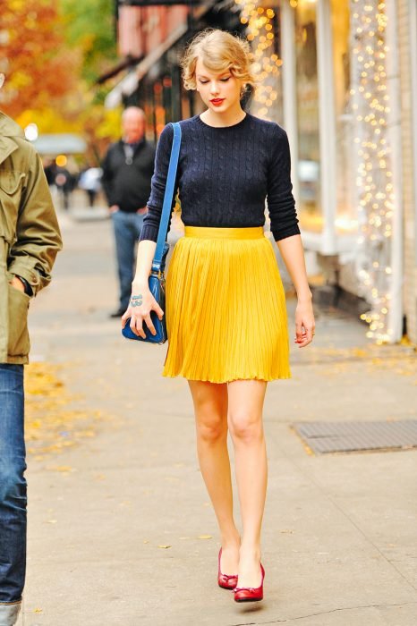 Chica de falta amarilla caminando por la calle