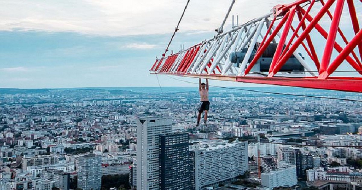 d3 11.jpg?resize=1200,630 - Un adolescent casse-cou se suspend d'une main à une grue située à 200 mètres au-dessus de la rue