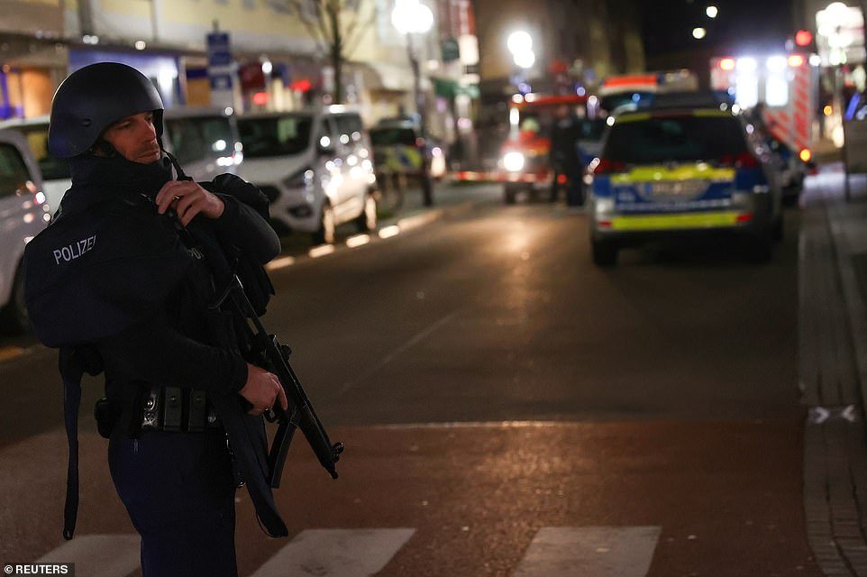 A police officer secures the area around two shisha bars after a shooting in Hanau near Frankfurt, Germany