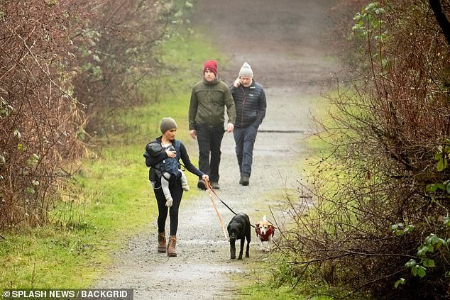 Meghan Markle is pictured above taking her two dogs for a walk with baby Archie with Canadian security guards
