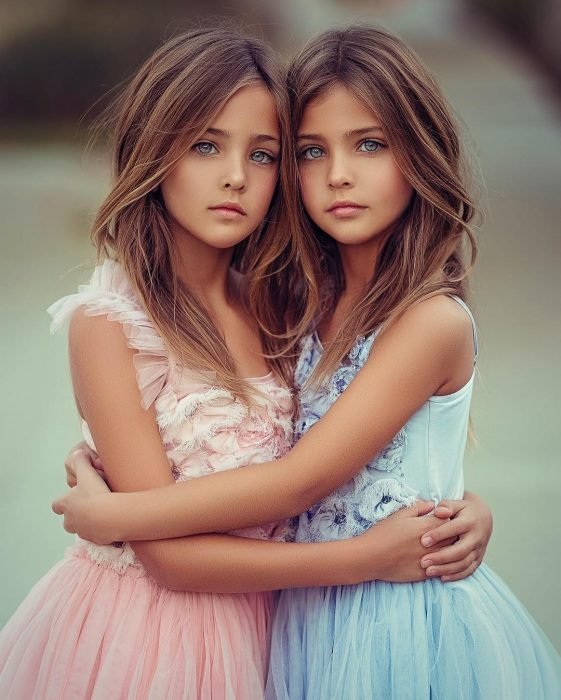 Gemelas Ava Marie y Leah Rose Clements en sesión fotográfica con vestidos rosa y azul