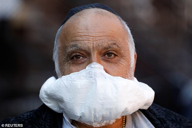 Other have resorted to crafting masks out of household items. A man is seen using a nappy as a makeshift face mask in Brooklyn, New York City