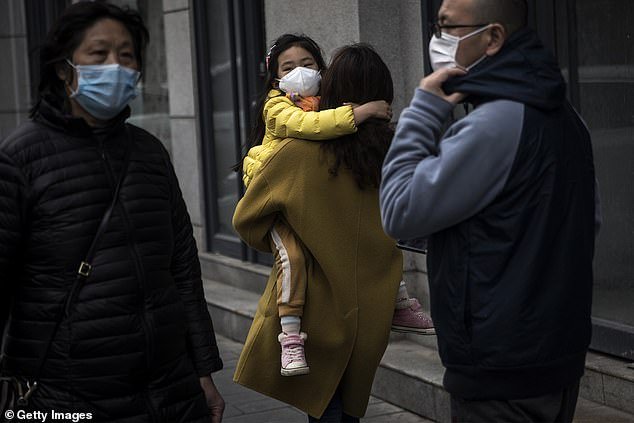 A mother holding her daughter walking in the street in Wuhan, Hubei Province, in China