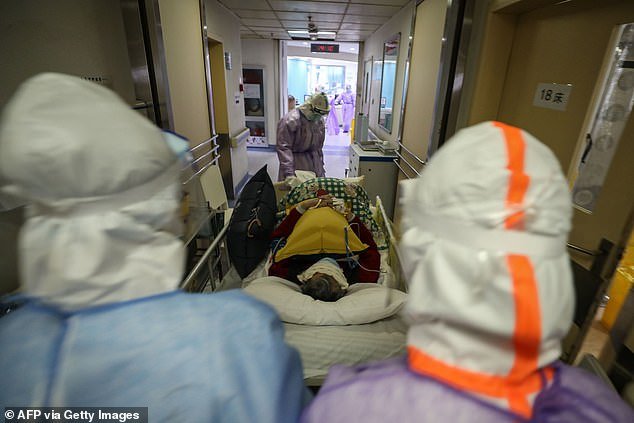 This photo taken on February 28, 2020 shows medical staff transferring a patient infected by the COVID-19 coronavirus at the Red Cross hospital in Wuhan in China