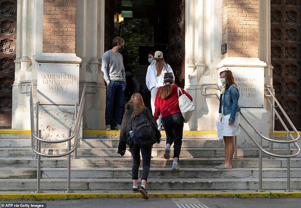AUSTRIA: Pupils walk up the steps of the Akademisches Gymnasium high school in Vienna this morning as some pupils return to their classrooms after more than a month away from school
