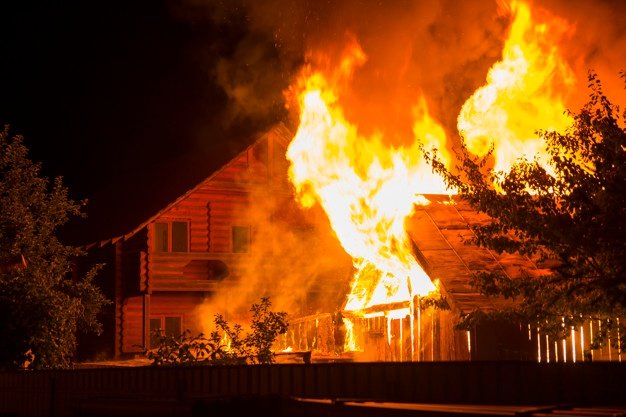 Casa de madera en llamas en la noche | Foto Premium