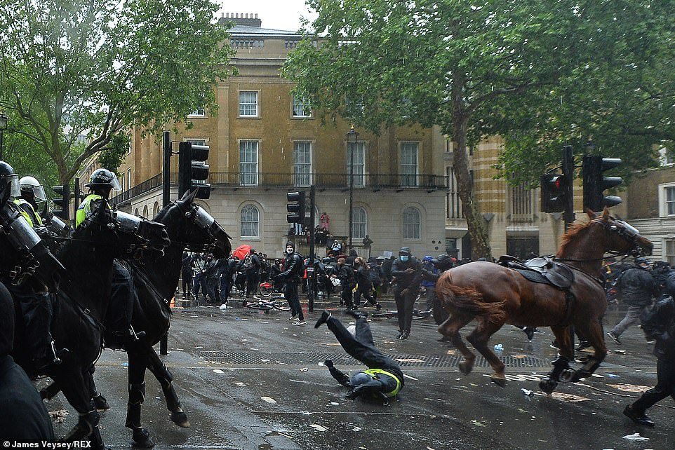 A female police officer was injured after her horse slammed her into a traffic light, sending its rider flying to the ground after being spooked by projectiles thrown by protestors