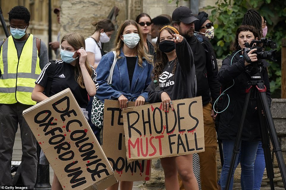 Demonstrators hold placards during a protest called by the Rhodes Must Fall campaign outside Oxford University