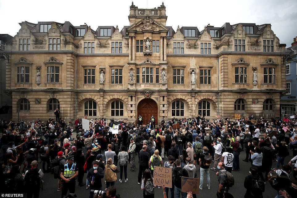Protesters gather in front of the Cecil Rhodes statue outside Oriel College in Oxford and demand for it to be taken down