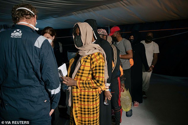 Migrants wearing face masks as a means of protection against the coronavirus disease (COVID-19) wait to disembark from the German NGO search and rescue ship Sea-Watch 3, before being transferred on board the Moby Zaza ferry to be quarantined, in the port of Porto Empledocle, Italy on Sunday