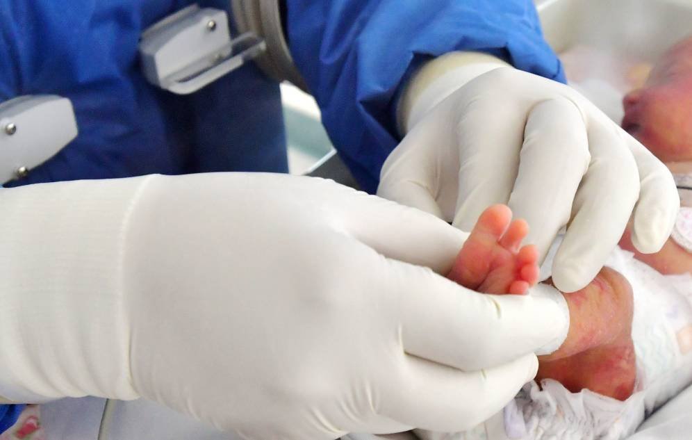Foto: Personal sanitario atiende a un recién nacido con sospecha de covid-19. (EFE)