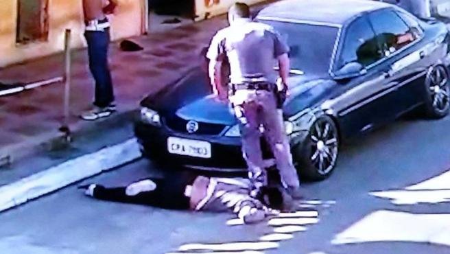 Captura del vídeo en la que se observa el momento en que el policía pisa el cuello de la mujer.