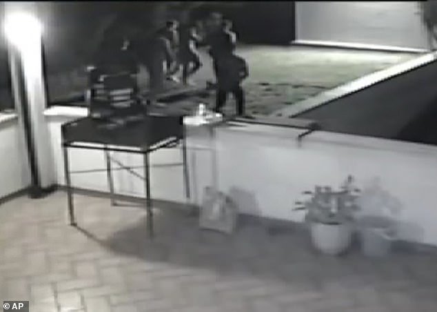This frame grab made from video surveillance released by Italian police yesterday shows a group of people walking towards a dark corner of a garden of a villa