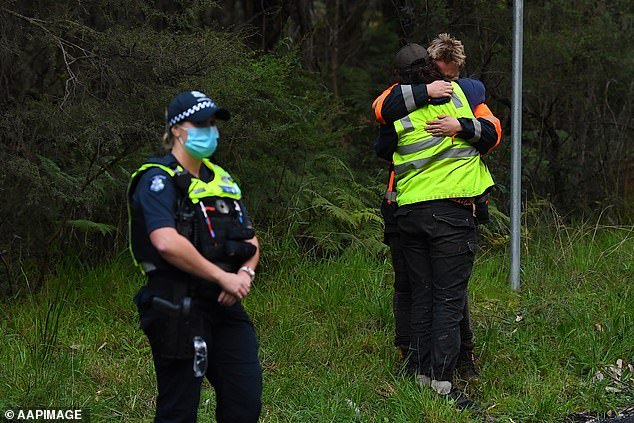 Distraught rescuers at the scene comfort each other after the search came to a tragic end