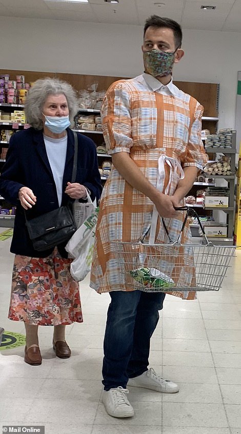 Simon, pictured in the replica Gucci gown while browsing a food outlet, said the fit of the dress made him look uncomfortable