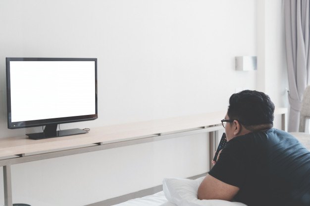 Hombre viendo la televisión en casa | Foto Premium