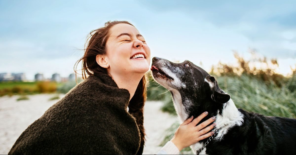 girl smiling with dog getty 661789463 e1606416456283.jpg?resize=1200,630 - La perte d'un chien peut être plus difficile que celle d'un proche