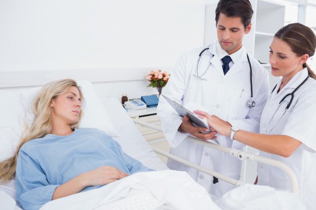 Mujer hospitalizada y doctores | Foto Premium