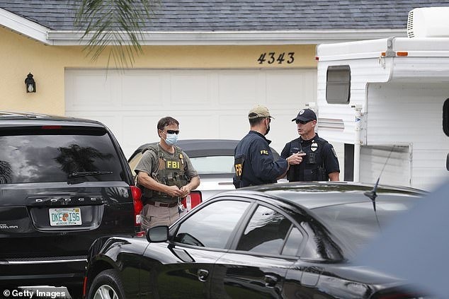 FBI agents talks with a North Port officer while they collect evidence from the home of Brian Laundrie on Monday